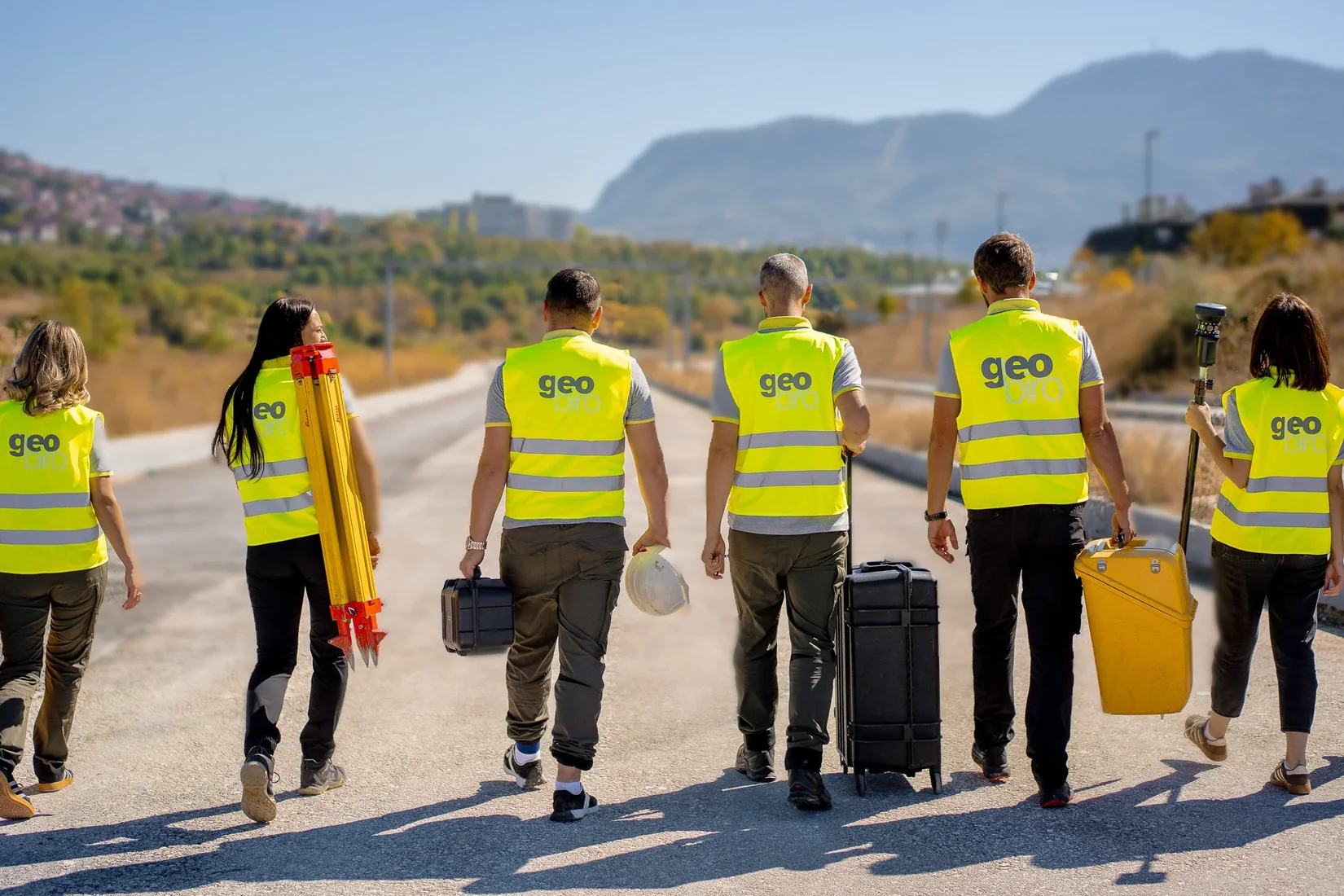 Geobiro team carrying survey equipment on site.