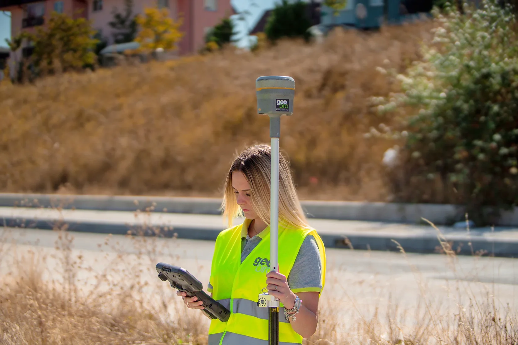 Geobiro surveyor collecting site measurements with a GNSS receiver and controller.